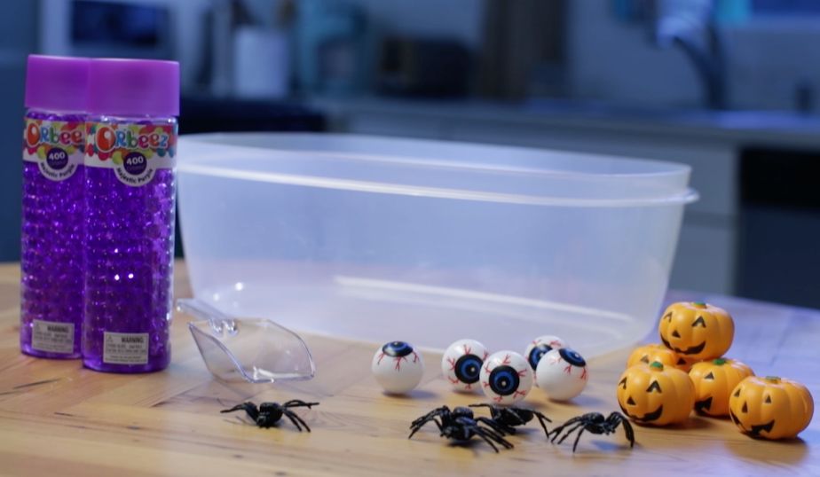 plastic bin, purple orbeez, spiders, pumpkins, eyeballs, plastic scoop